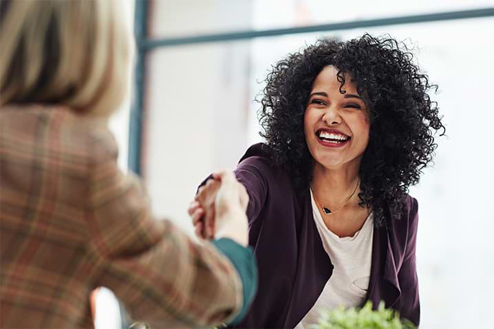 Two people shaking hands and smiling Two people shaking hands and smiling